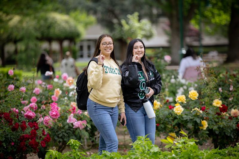 Two students with stingers up hand gesture